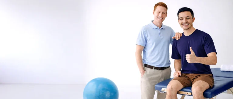 Physiotherapist and a smiling patient in a treatment room